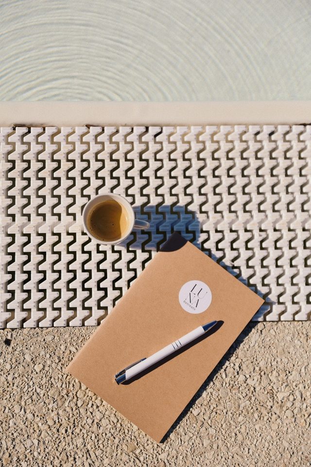 A Luna notebook and an espresso at the edge of a pool